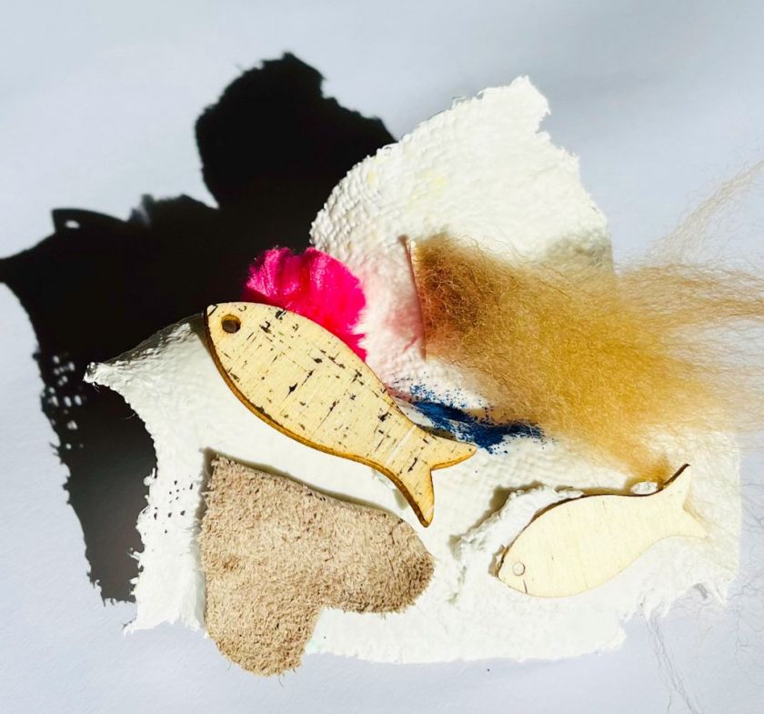 Gipsabdruck eines Körperteiles beklebt mit verschiedenen bunten Materialien