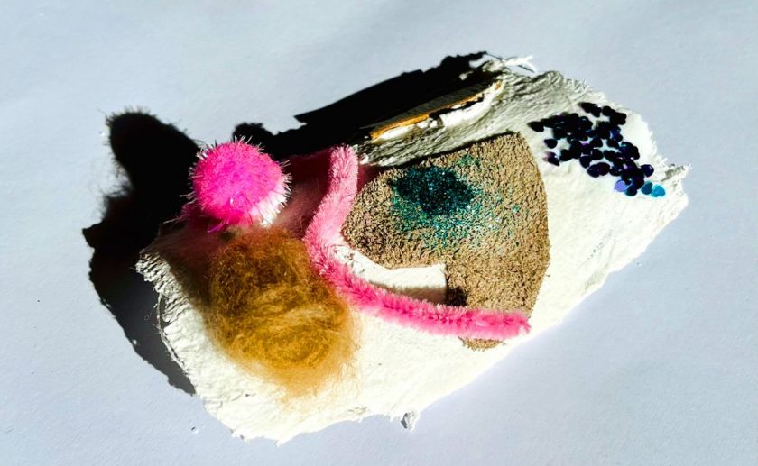 Gipsabdruck eines Körperteiles beklebt mit verschiedenen bunten Materialien