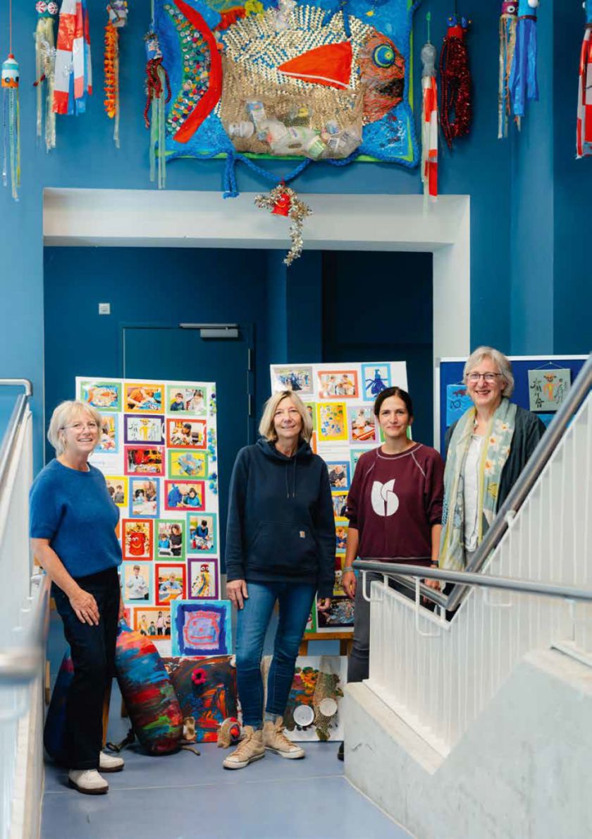 4 Personen stehen in einem Atelier