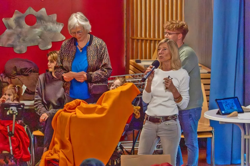 Projektleiterin spricht bei der Aufführung des inklusiven Theaterprojekts Decken.Farben.Jahreszeiten vor Kindern und Jugendlichen mit und ohne Behinderung in einem Veranstaltungsraum in Hamburg.