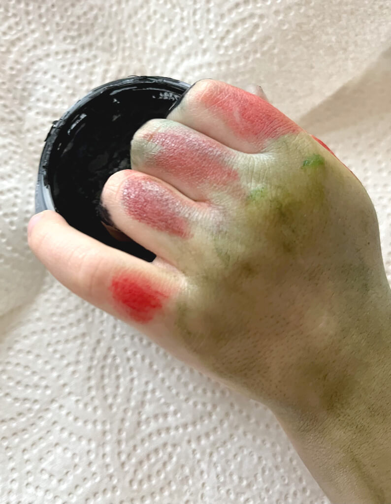 Kinderhand im Farbtopf